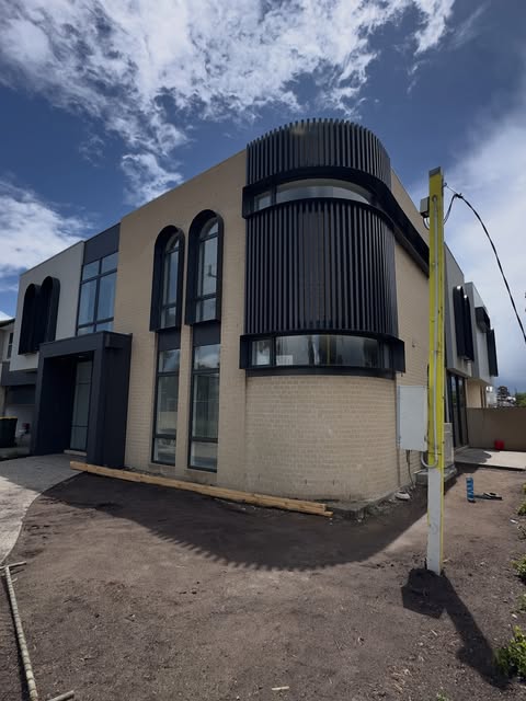 Brick building with curved facade and black architectural cladding