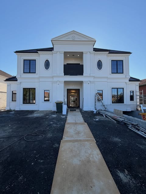 Two-storey white home during exterior finishing works